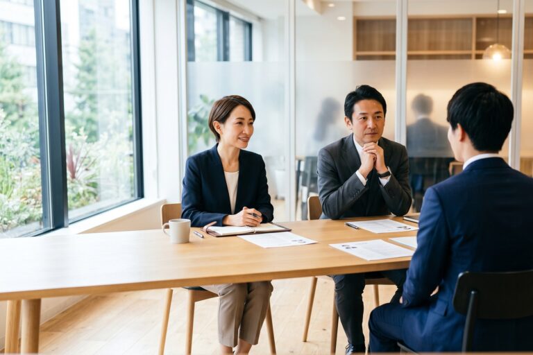 明るいオフィスで採用面接を行う面接官と候補者。第一印象が評価に影響するハロー効果のイメージ